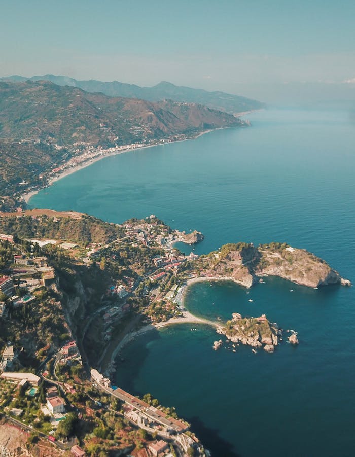 Breathtaking aerial shot of Taormina, Sicily showcasing the vibrant coastline and azure sea.